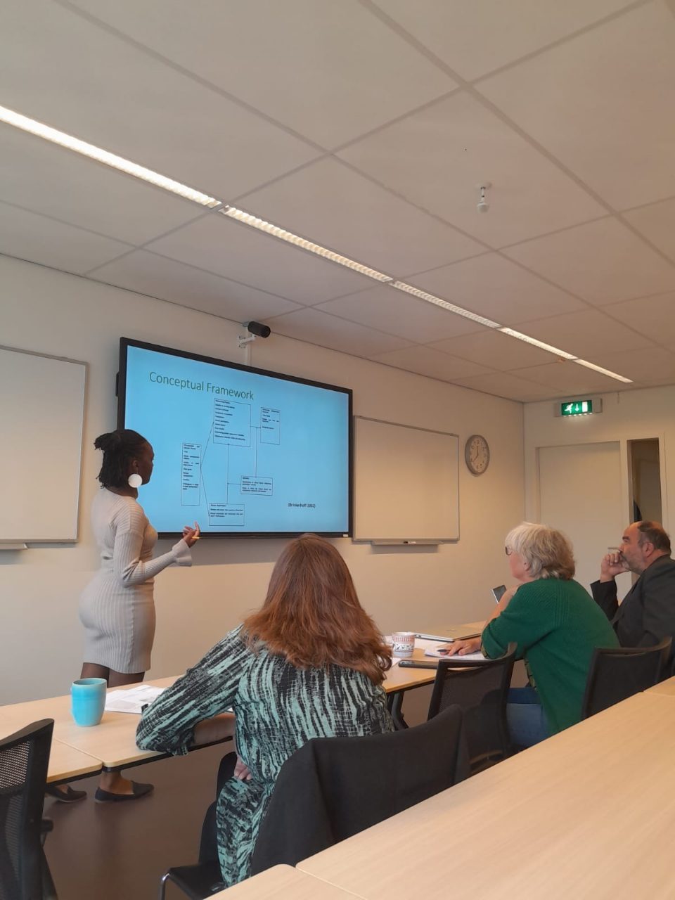 Njoki presenting a conceptual framework for evaluating partnerships to a seminar room.